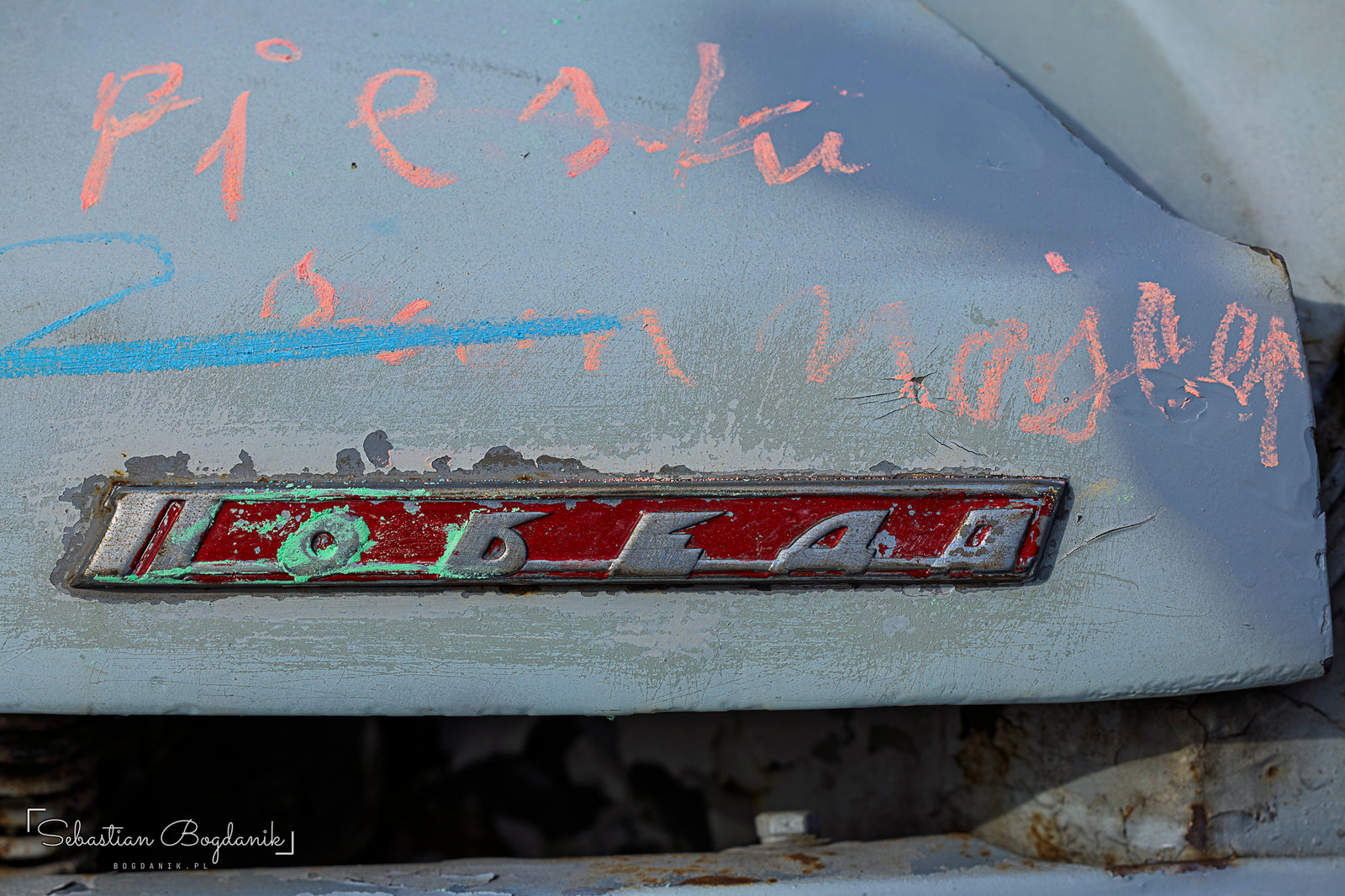 The Pobeda up close: the Cyrillic name means “Victory,” next to a well-weathered GAZ badge (1/2)