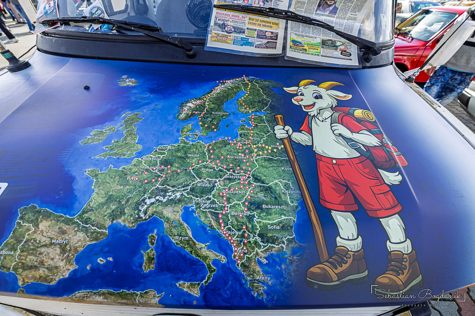 A map of Europe across the whole hood, with the route drawn in and a goat with a walking stick and a backpack