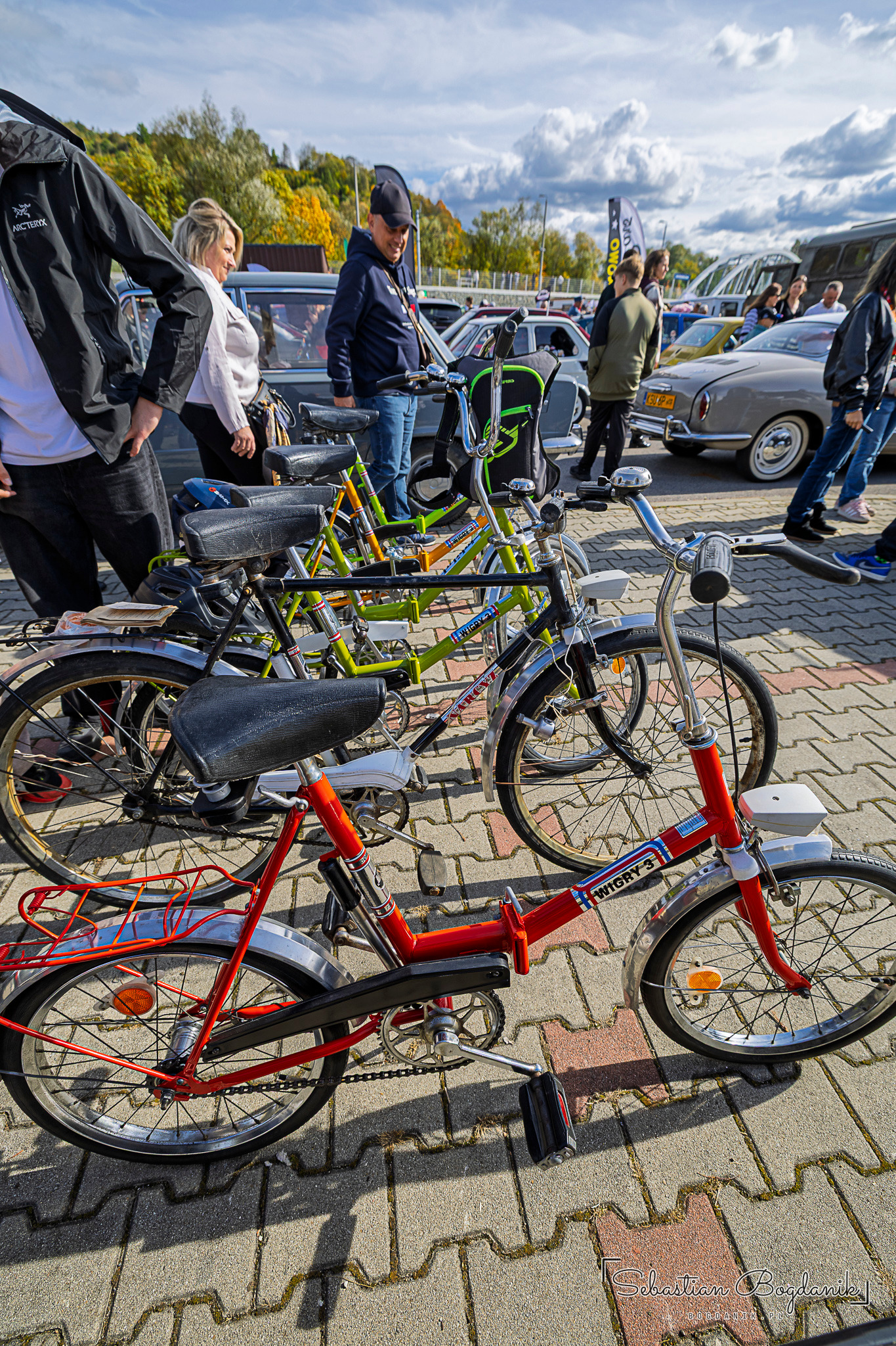 Kilka składanych rowerów w różnych kolorach ustawionych obok siebie na placu.